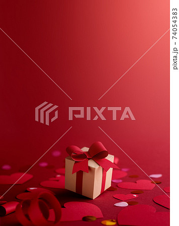 Paper art Valentine's day concept banner with hand made gift box, paper cut ribbon, bow, and a lot of hearts. against dark red background with empty space for text. 74054383