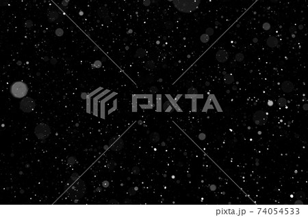 Bokeh of white snow on a black background. Snowfall - design element. 74054533