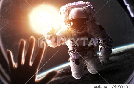 Astronaut in front of glowing Sun. Space science fiction visualization. Elements of this image furnished by NASA 74055559