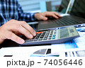 Businessman / accountant is doing calculations. Tax season. 74056446