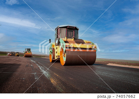 Large view on the road rollers working on the new road construction site Large view on the road rollers working on the new road construction site 74057662