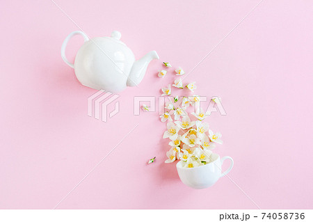 Creative layout of teapot and tea Cup with Jasmine flowers on a pink background. Jasmine tea. Creative layout of teapot and tea Cup with Jasmine flowers on a pink background. Jasmine tea. 74058736