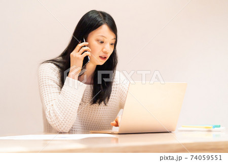 テレワークでスマホで話す女性 74059551