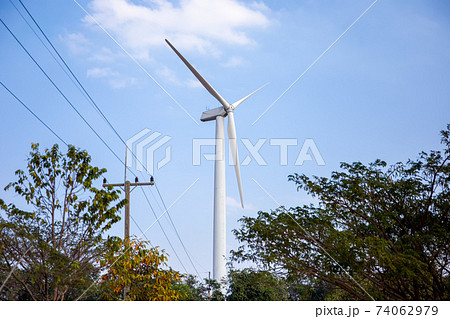Wind power station. Wind generators stand in agricultural fields on mountain. Wonderful landscape shot from a great height. Modern green energy. 74062979