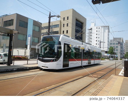 富山市内を走る近代的な路面電車 74064337