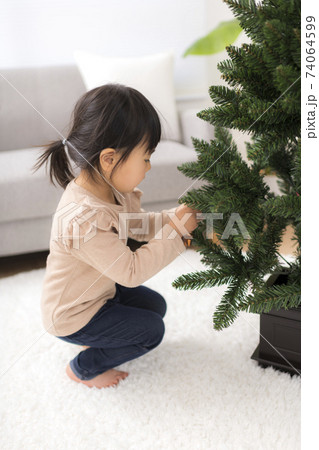 クリスマスの飾り付けをする女の子 74064599