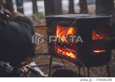 冬のキャンプ、薪ストーブに火吹き棒で火力を上げる 74066306