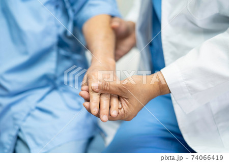 Holding hands Asian senior or elderly old lady woman patient with love, care, encourage and empathy at nursing hospital ward, healthy strong medical concept Holding hands Asian senior or elderly old lady woman patient with love, care, encourage and empathy at nursing hospital ward, healthy strong medical concept 74066419