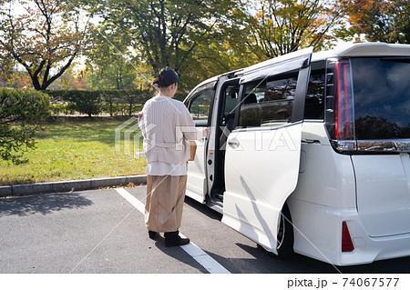 スライドドアの車に乗る主婦の写真素材