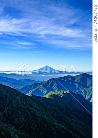 奥秩父の山並みと快晴の空と富士山のシルエットの写真素材