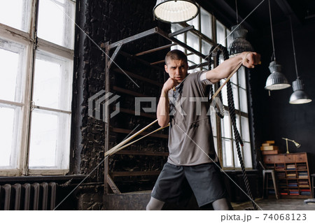 Cool man fighter in boxing bandages trains in the gym. Mixed martial arts Cool man fighter in boxing bandages trains in the gym. Mixed martial arts 74068123
