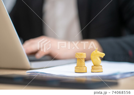 Two white chess pieces standing near laptop 74068556