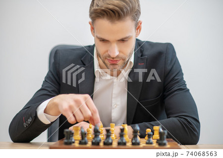 Young man placing chess pieces on chessboard Young man placing chess pieces on chessboard 74068563