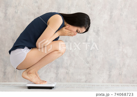 体重をはかる女性 体重をはかる女性 74068723