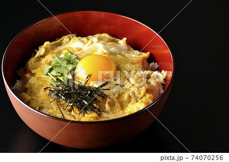 卵黄、みつば、刻み海苔の乗っている玉子丼を黒背景で撮影 74070256