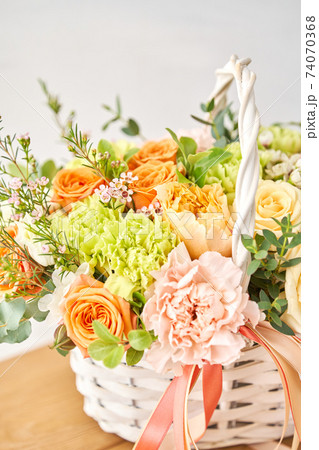 Small flower shop and Flowers delivery. Flower arrangement in Wicker basket. Beautiful bouquet of mixed flowers on wooden table. Handsome fresh bouquet. Small flower shop and Flowers delivery. Flower arrangement in Wicker basket. Beautiful bouquet of mixed flowers on wooden table. Handsome fresh bouquet. 74070368