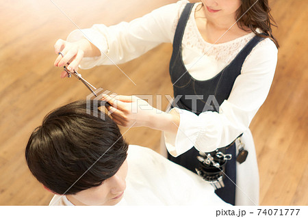 客の髪を切るヘアスタイリストの手元 客の髪を切るヘアスタイリストの手元 74071777