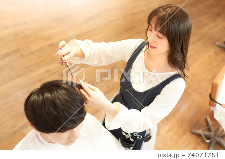 客と会話しながら髪を切るヘアスタイリスト 客と会話しながら髪を切るヘアスタイリスト 74071781