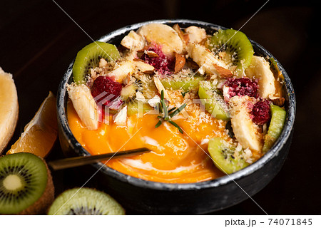 Pumpkin soup with citrus fruits on a rustic setup Pumpkin soup with citrus fruits on a rustic setup 74071845