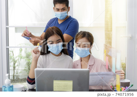 Asian Business Team Meeting Brainstorming Business start up working at Private Home Office social distancing among Coronavirus outbreak New generation business people meeting analysis work from laptop 74071956