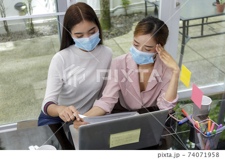 Asian Business Team Meeting Brainstorming Business start up working at Private Home Office social distancing among Coronavirus outbreak New generation business people meeting analysis work from laptop 74071958
