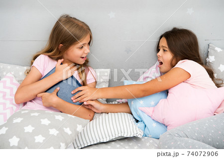 Kids lay in bed fight for book. Friends have some problems. 74072906