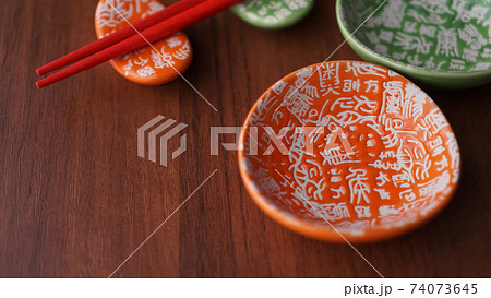 Set of ceramic dishes and red sushi sticks on wooden background 74073645