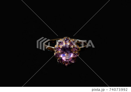 Beautiful golden ring with purple gemstone isolated on black background 74073992
