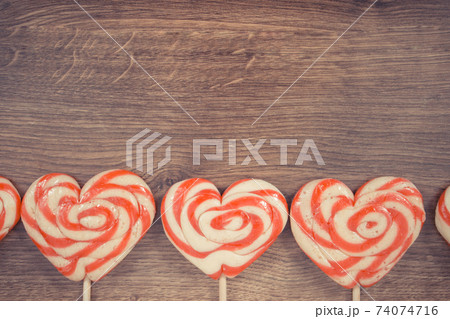 Sweet lollipop in shape of heart on board Sweet lollipop in shape of heart on board 74074716