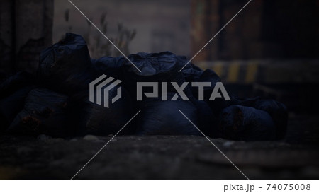 Plastic trash bags on curb outside city building 74075008