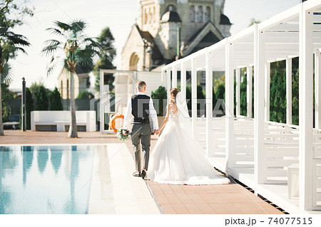 Wedding couple holding hands, groom and bride together on wedding day 74077515