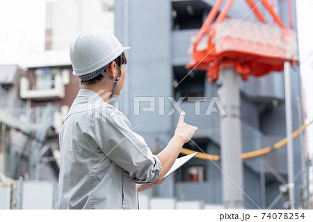 建築現場で働くヘルメットをかぶった若い作業員の後ろ姿 建築現場で働くヘルメットをかぶった若い作業員の後ろ姿 74078254
