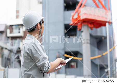 建築現場で働くヘルメットをかぶった若い作業員の後ろ姿 74078255