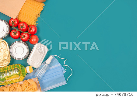 Food and medicine donations on green background with copy space - pasta, fresh vegatables, canned food, baguette, disposable face mask and hand sanitazer spray bottle. Food bank, food delivery concept Food and medicine donations on green background with copy space - pasta, fresh vegatables, canned food, baguette, disposable face mask and hand sanitazer spray bottle. Food bank, food delivery concept 74078716