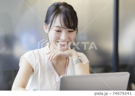 PCを見て微笑む 女性 ビジネスシーン PCを見て微笑む 女性 ビジネスシーン 74079341