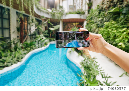 Woman photographing swimming pool Woman photographing swimming pool 74080577