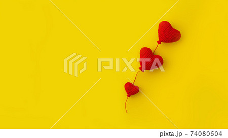 three knitted red heart-shaped balloons in row on yellow background, concept of love, banner 74080604