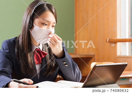 マスクをしてタブレット学習する女子高生 高校生 生徒の写真素材