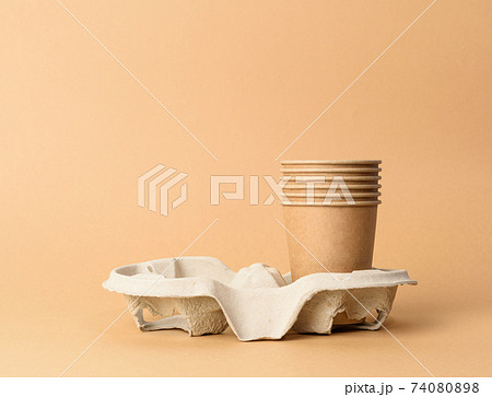 brown disposable cups in paper holder on blue background, rejection of plastic 74080898