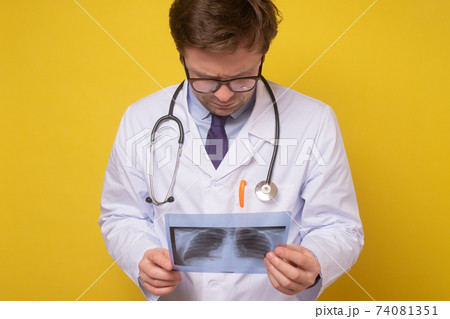 Radiologist man checking xray isolated on yellow background Radiologist man checking xray isolated on yellow background 74081351