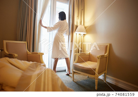 Woman in bathrobein hotel room. Brunette girl 74081559
