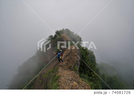 霧に包まれる戸隠山の蟻の塔渡りを歩く登山者 霧に包まれる戸隠山の蟻の塔渡りを歩く登山者 74081726