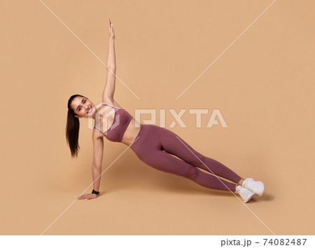 Smiling Young Woman Doing Side Plank Balance Exercise 74082487
