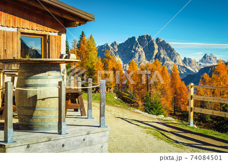 Wooden house with terrace in the colorful autumn forest, Dolomites 74084501