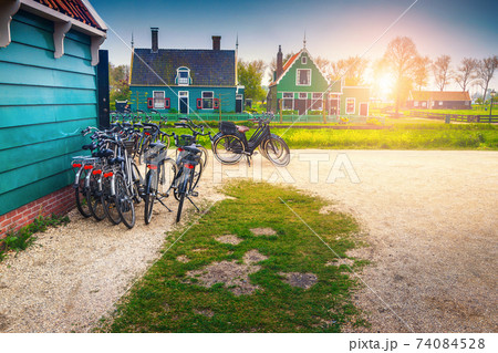 Tourist bicycles and cute wooden houses in Zaanse Schans, Netherlands  Tourist bicycles and cute wooden houses in Zaanse Schans, Netherlands  74084528