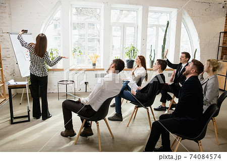 Female speaker giving presentation in hall at workshop. Audience or conference hall. Side view of unrecognized participants. Female speaker giving presentation in hall at workshop. Audience or conference hall. Side view of unrecognized participants. 74084574