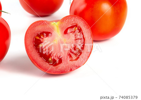 a group of tomatoes on a white background, with shadows. One tomato cut, studio photo, isolate, tomatoes washed 74085379