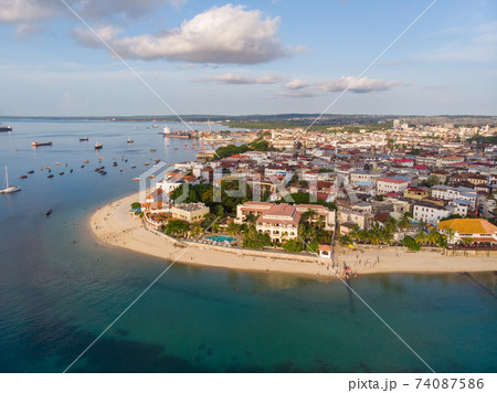 Zanzibar Aerial Shot of Stone Town Beach with Traditional Dhow Fisherman Boats in the Ocean at Sunset Time 74087586