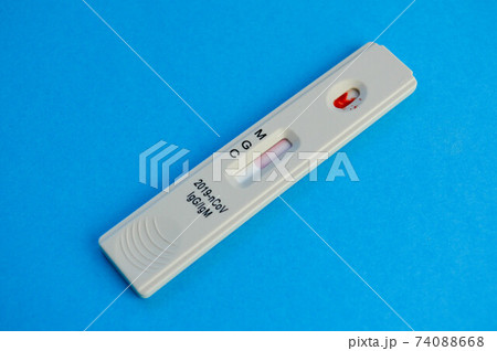 coronavirus test lies on a blue background. a drop of venous blood on the test strip. express diagnostics of coronavirus. the test shows the presence of IgG and IgM antibodies 74088668