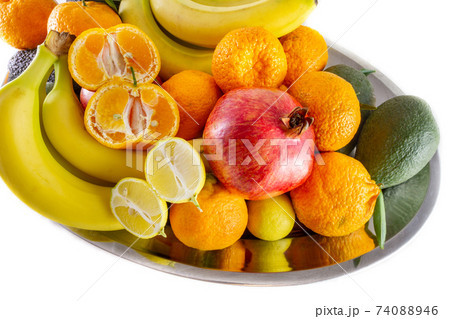 Assorted fruit and vegetable platter of bananas, pomegranate, lemon, tangerine and avocado. Assorted fruit and vegetable platter of bananas, pomegranate, lemon, tangerine and avocado. 74088946